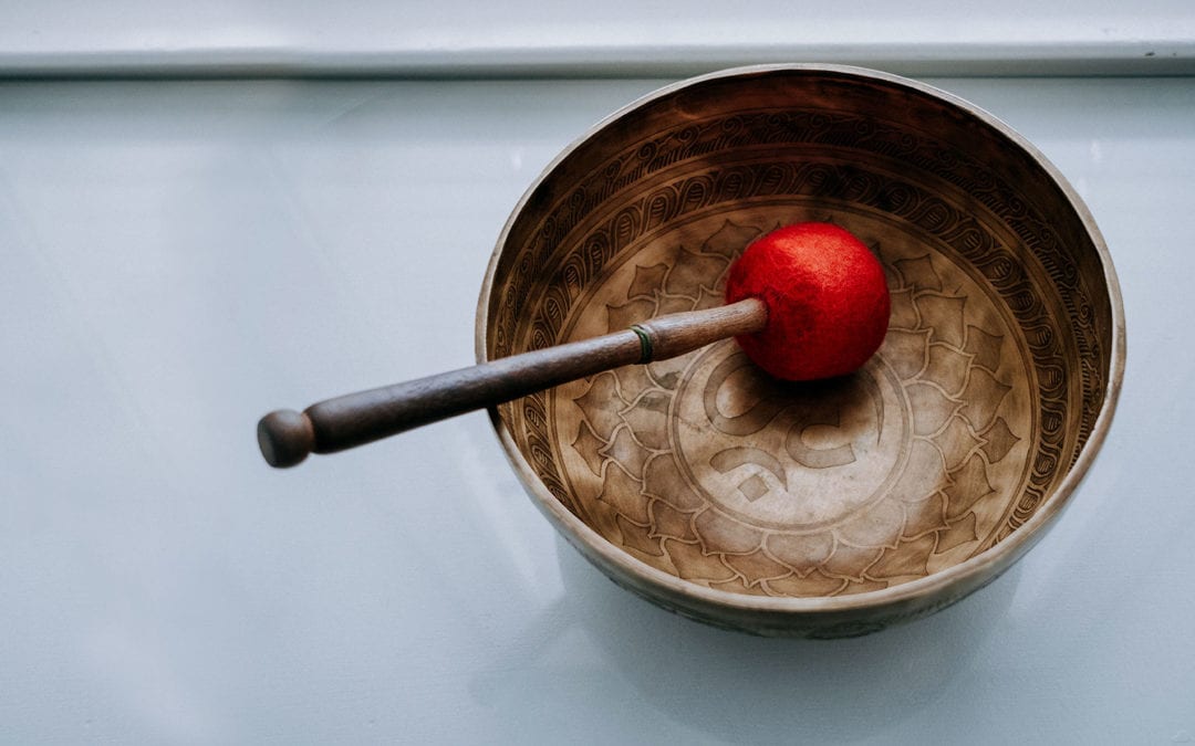 Tibetan singing bowl with wooden mallet with a red ending.